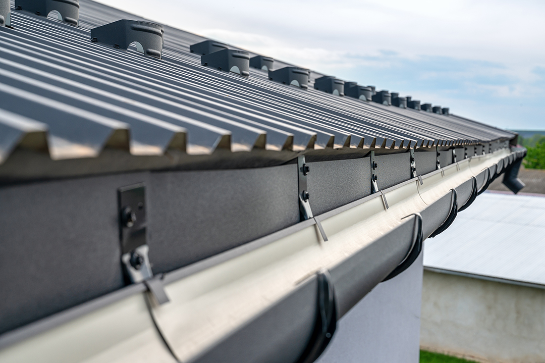 Gutter system for a metal roof. Holder gutter drainage system on the roof.