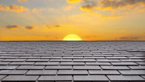 Close-up picture of a roof with the sun in the background.